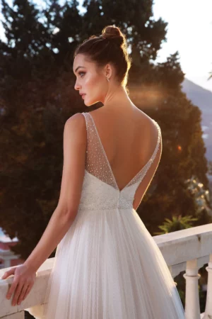 Vue arrière de la robe de mariée 88118, mettant en valeur son dos en V perlé et sa longue jupe en tulle aérien, pour un effet vaporeux et élégant.