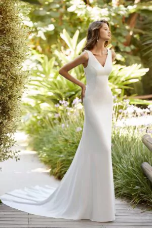 Robe de mariée Adriana Allier en crêpe, dos illusion en dentelle et col en V, photographiée dans un jardin tropical.