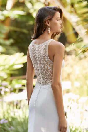 Robe de mariée Adriana Allier en crêpe, dos illusion en dentelle et col en V, photographiée dans un jardin tropical.