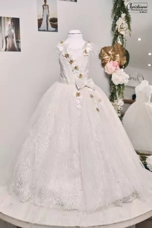 Robe enfant en dentelle et tulle avec appliqués floraux 3D, touches dorées, plumes légères et jupe volumineuse.