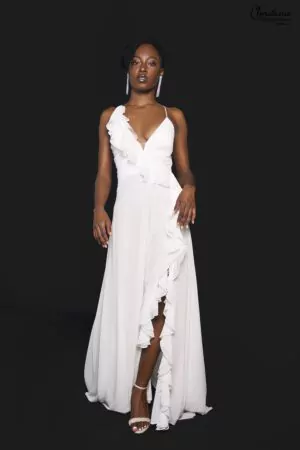 Robe fluide blanche à dos nu avec bretelles croisées et volants, parfaite pour un mariage décontracté et élégant.