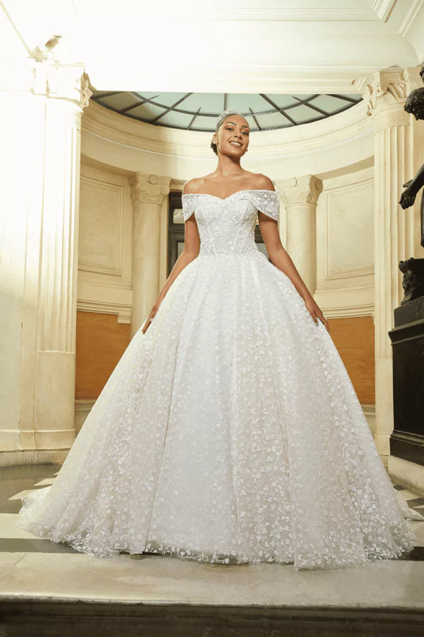 Robe de mariée princesse à épaules dénudées avec broderies florales pailletées et jupe ample en tulle scintillant, parfaite pour un mariage magique.