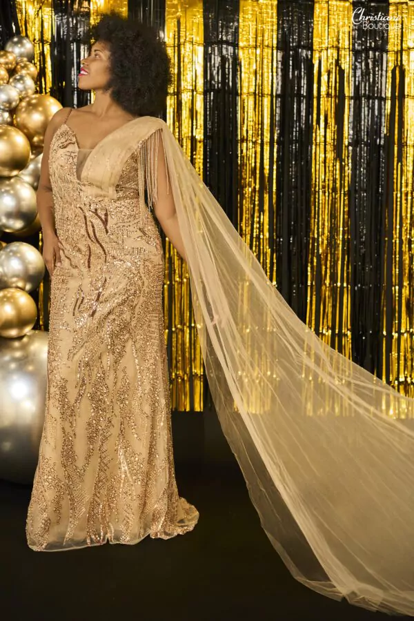 Robe de soirée dorée avec sequins, décolleté en V et cape fluide en tulle.