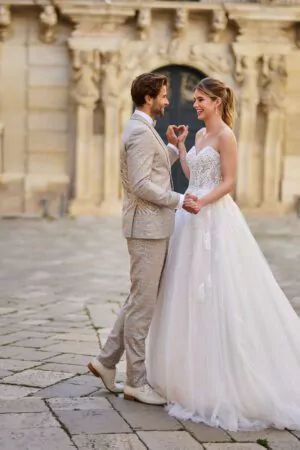 Robe de mariée A-line avec corset en dentelle, manches amovibles et jupe fluide en tulle scintillant.